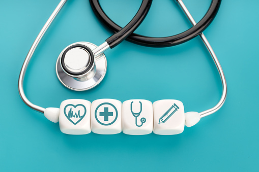 Health care or medicine concept. Healthcare medical symbol on white blocks and stethoscope on green background