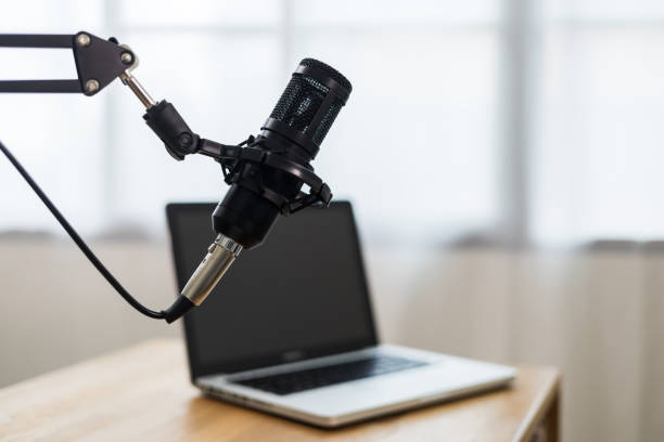 istock Condenser microphone in recording home studio. Content creator working with laptop host streaming radio podcast interview conversation at home broadcast studio recording voice over radio 1406692796