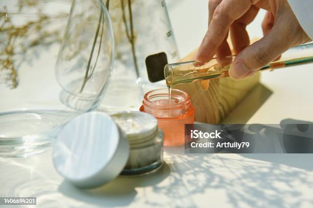 Scientist Mixing Natural Skin Care Beauty Products Organic Botany Extraction And Scientific Laboratory Glassware Blank Label Cosmetic Container For Branding Mockup Stock Photo - Download Image Now