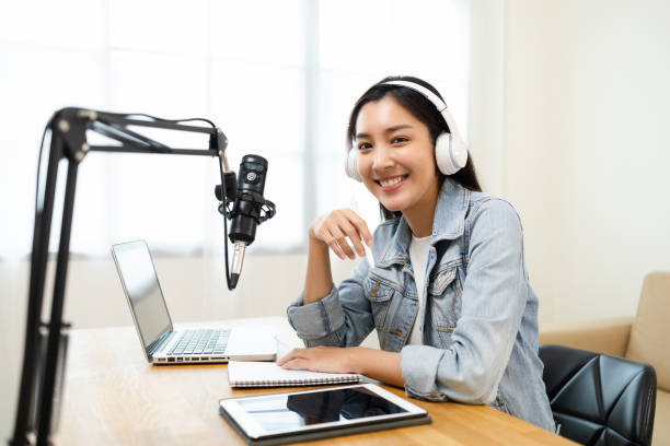 Content creator woman host streaming her a podcast on laptop with headphones and microphone interview cheering guest conversation at broadcast studio. Blogger motivation recording voice over radio. la mujer creadora de contenido la anfitriona le transmite un podcast en una computadora portátil con auriculares y micrófono para animar la conversación de los invitados en el estudio de transmisión. motivación blogger grabando voz por radio.