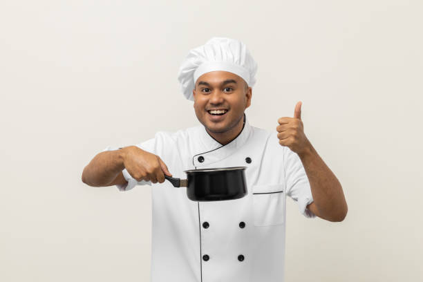 istock Young asian man chef in uniform holding soup pot utensils cooking in the kitchen various gesture action on isolated background. Indian man Occupation chef restaurant and hotel. 1406694544
