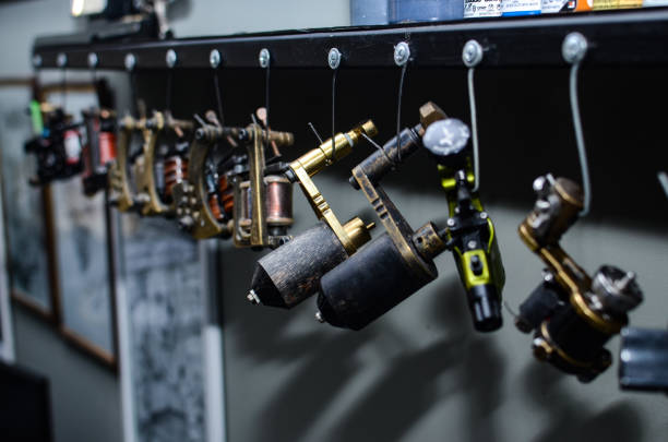 close up tattoo machine. Man creating picture on hand with it in salon