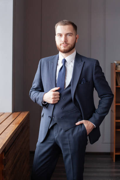 istock Modern businessman in deep blue suit standing in office 1406697294