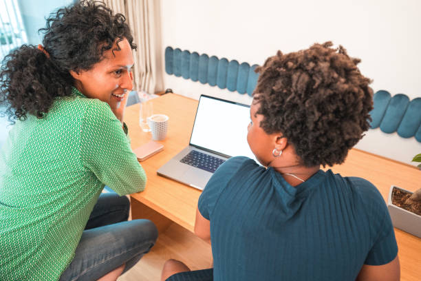 istock Young Hispanic Female Teaching Her Mother To Use A Modern Laptop 1406697448