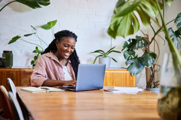 istock Young woman working remotely from home on a laptop and smiling 1406697902