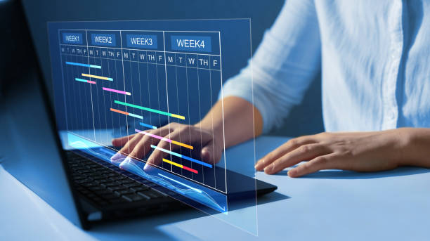 istock Project manager working on laptop and updating tasks and milestones progress planning with Gantt chart scheduling interface for company on virtual  screen.Business Data Management System 1406697920
