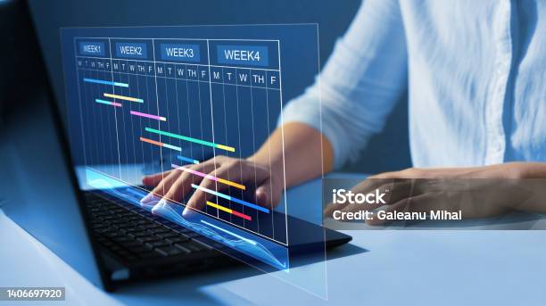 Project Manager Working On Laptop And Updating Tasks And Milestones Progress Planning With Gantt Chart Scheduling Interface For Company On Virtual Screenbusiness Data Management System Stock Photo - Download Image Now