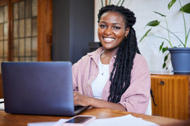 istock Smiling young woman working online from home using a laptop 1406698113