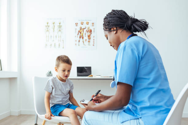 istock Doctor Examining Boy While Writing On Clipboard 1406698226