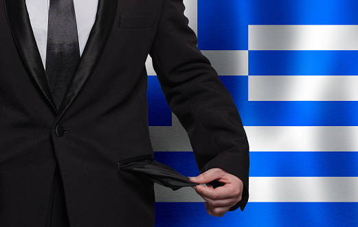 Poverty, financial difficulties, bad economy, tax or social problem in Greece concept. Businessman with empty pocket on Greek flag background.