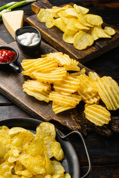 istock Salt Vinegar Flavored Potato Chips on old dark  wooden table background 1406701220