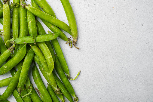 Green peas Freshly harvested , on gray stone table background, top view flat lay, with copy space for text