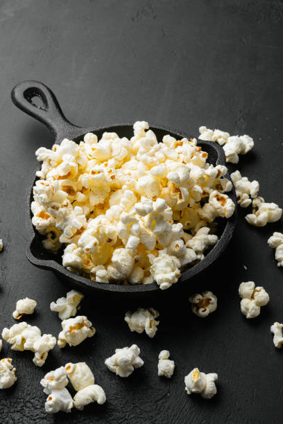istock Salted popcorn on black dark stone table background 1406704003