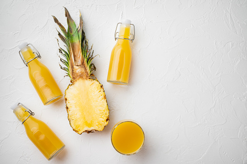Pineapple cocktail or juice set, on white stone table background, top view flat lay, with copy space for text