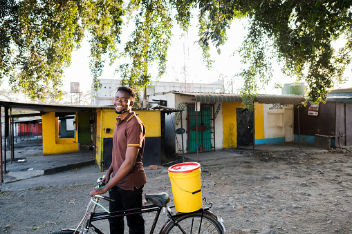 Portrait young African man new business owner with delivery bicycle