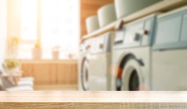 istock Laundry room table background. Blurred home laundry room with wooden table display for product. 1406706438