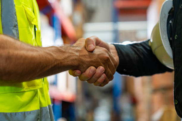 Caucasian man engineer working with manager in factory warehouse Caucasian man engineer shaking hands with factory manager in manufacturing warehouse. Male warehouse worker working and discussion with supervisors. Business industry engineering and manufacturing technology concept. labor union stock pictures, royalty-free photos & images