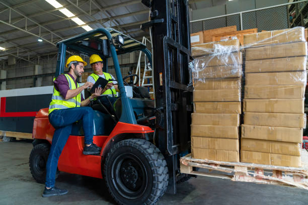 homme travailleur travaillant ensemble dans l’entrepôt de l’usine. - chariot élévateur photos et images de collection