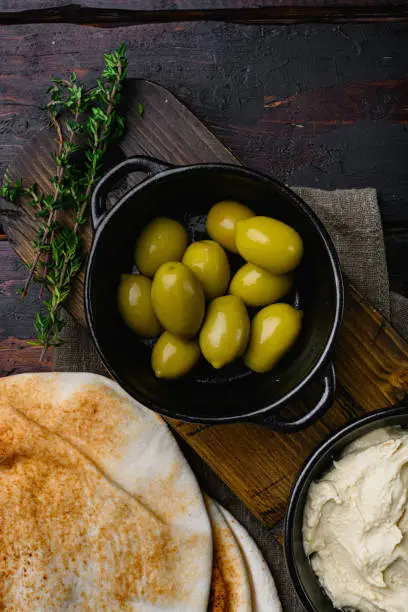 Lebanese bread, pita bread and olives, on old dark  wooden table background, top view flat lay, with copy space for text