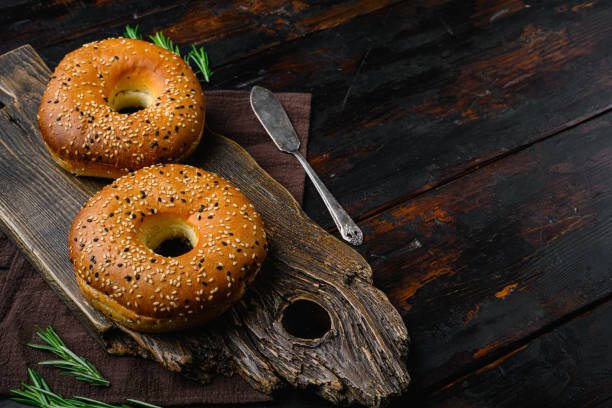 istock Fresh Bagels with Sesame set, on old dark  wooden table background, with copy space for text 1406709045