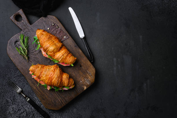 sándwich de croissant con salmón salado, sobre fondo de mesa de piedra oscura negra, vista superior plana, con espacio de copia para texto - smoked salmon cooking copy space food fotografías e imágenes de stock