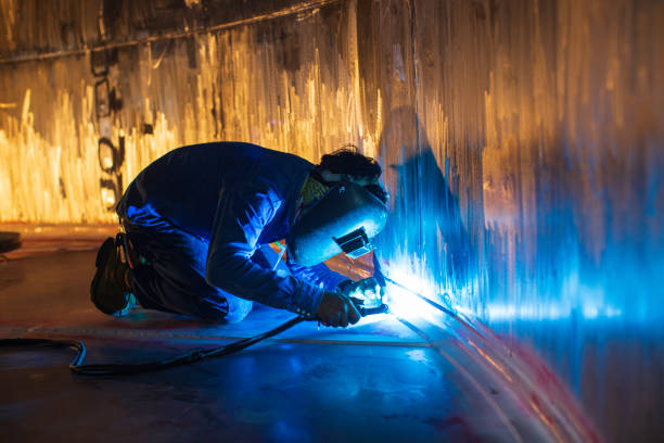 Welding  arc argon worker male repaired metal is welding sparks industrial construction tank stainless