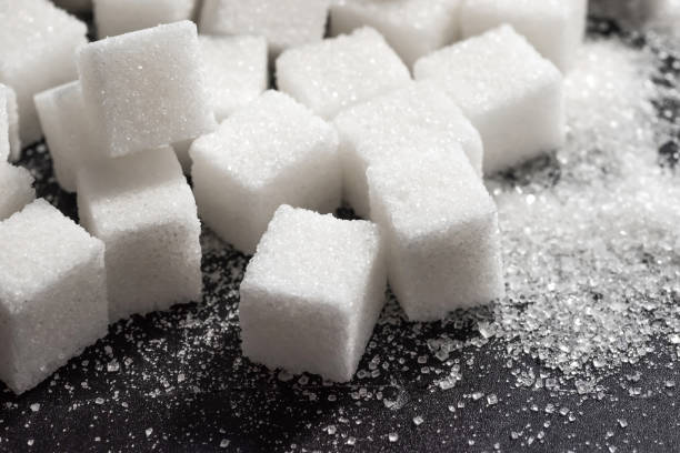 Cubes of refined sugar on a dark table close-up Cubes of refined sugar on a dark table close-up. sugar cube stock pictures, royalty-free photos & images