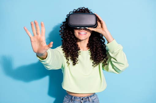 Photo of cheerful person raise arm wear vr glasses new experience isolated on blue color background.