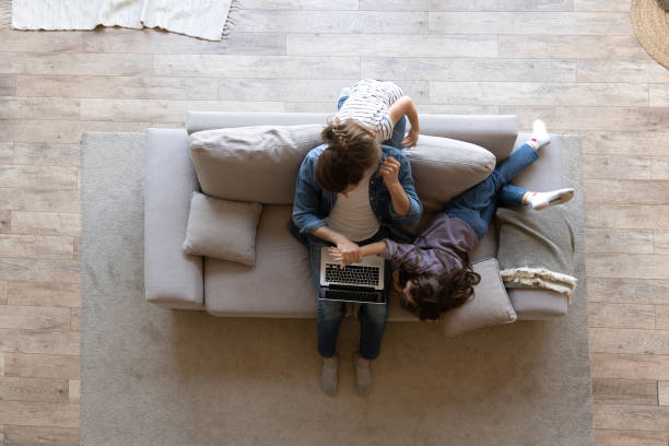 istock Caucasian male working from home with children. Work From Home Stressed Parent. Noisy active daughters playing at home 1406720121