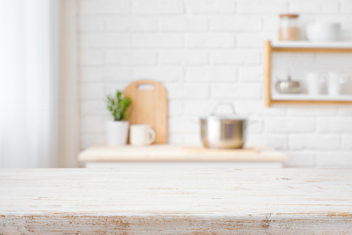 istock Wooden countertop with blurred kitchen utensils and furniture interior background 1406720334