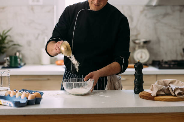 istock Anonymous Caucasian Cook Preparing Dessert, Pouring Flour into a Bowl 1406722992