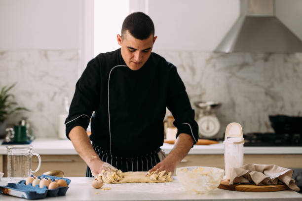 istock Happy Caucasian Professional Pastry Chef Kneading Dough in a Private Kitchen 1406722996