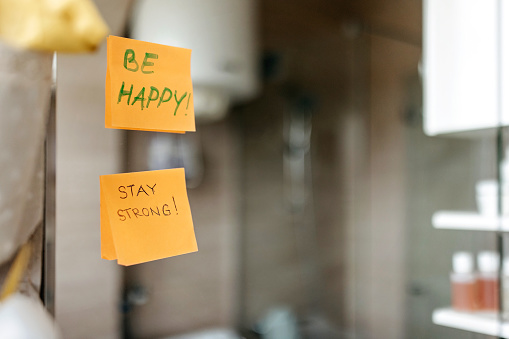 Supportive messages written on post-it notes, taped to a bathroom mirror.