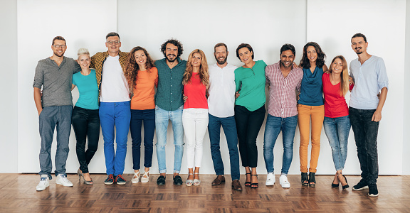 Modern, colorful business team standing for portrait, looking at camera and smiling