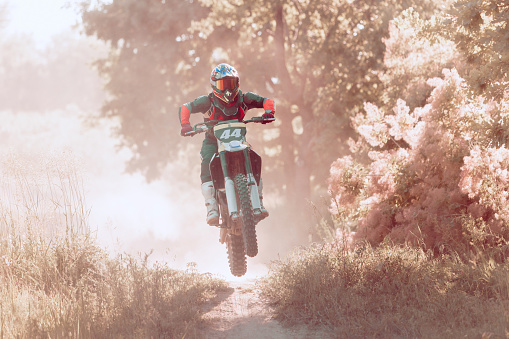 Speed and power. Live shot of male sportsman training on motorbike at hot summer day, outdoors. Motocross rider in action. Motocross sport, competition, male hobby, energy and ad