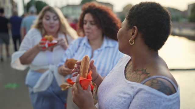 Female friends having delicious local street food