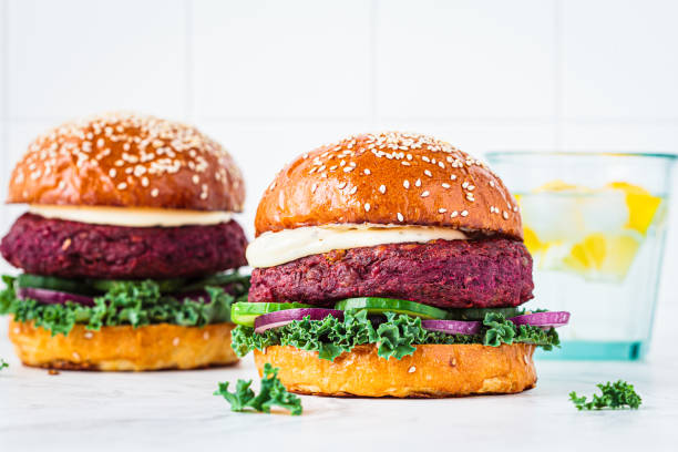 Beetroot vegan burger with kale, onion and cucumber. Alternative fast food.  Purple food. stock photo
