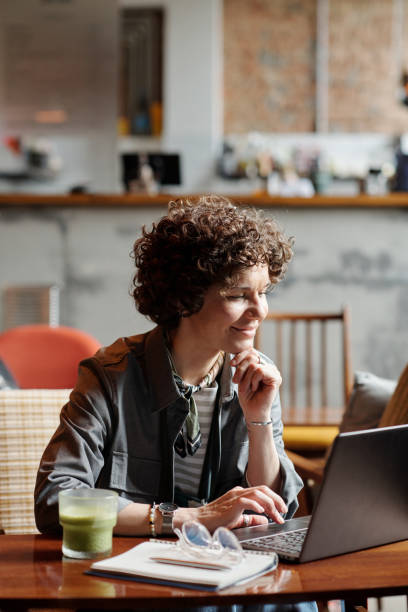 istock Happy middle aged businesswoman or freelancer networking by table in cafe 1406731782