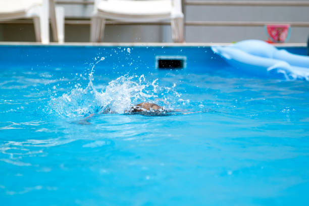 istock splash from a boy swimming in a pool 1406732846