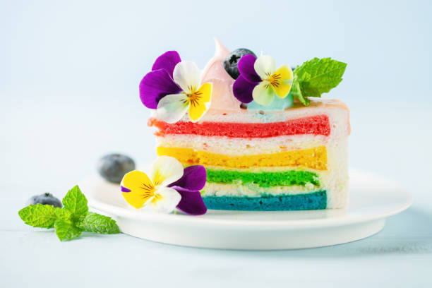 istock Delicious rainbow cake on plate on table on blue wooden background 1406735028