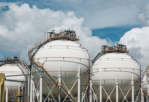 White spherical propane tanks containing fuel gas in the blue sky