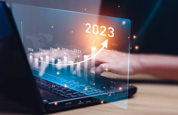 istock Businessman planning 2023 business growth on desk with virtual hologram chart graph. Calculate income and profit on investments and an increase in the indicators of positive growth, Return on Stocks 1406736664