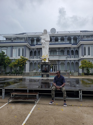 a man sitting in front of Mary status in Roman catholic church