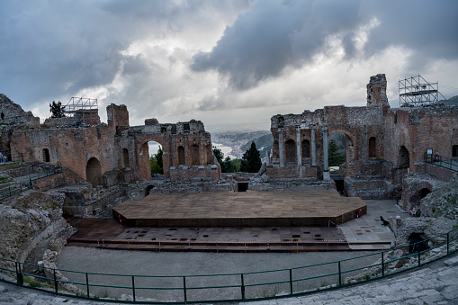 Ancient theater of Taormina ruins, Sicily. A Hellenistic theatre stood at Taormina from around the third century BC. Cloudy evening light.