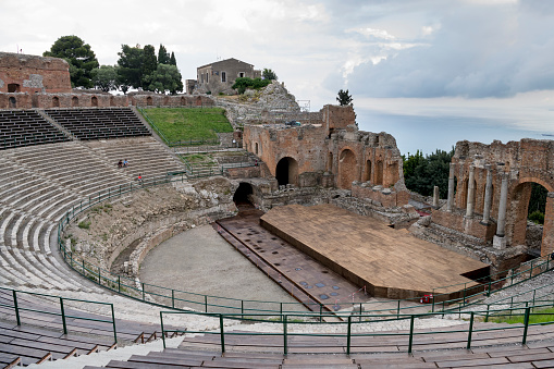 Ancient theater of Taormina ruins, Sicily. A Hellenistic theatre stood at Taormina from around the third century BC. Cloudy evening light.