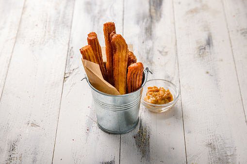 Spanish churros on white wooden table side view