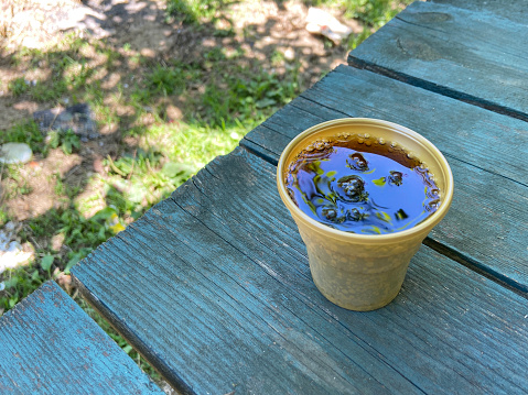 Plastic cup of coke on the outdoor wood table