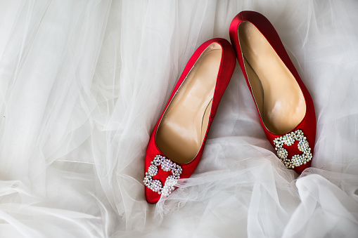 Red wedding shoes with jewels on a white background