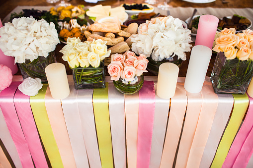 The flowers, candles and colored ribbons on the wedding table.