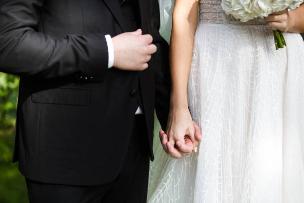 istock Bride and groom holding hands 1406746762